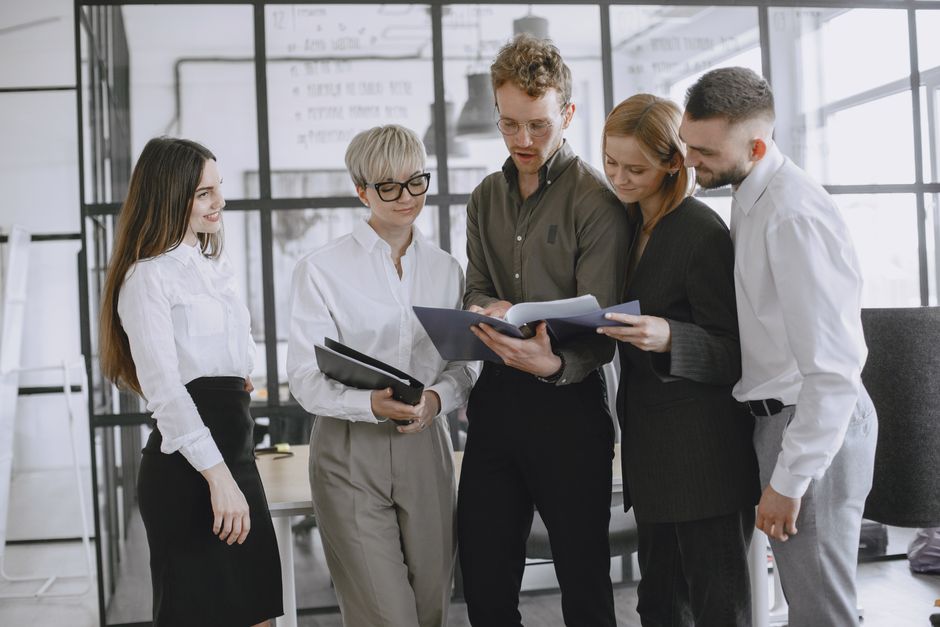 pexels photo 4872059 4872059 A diverse group of professionals collaborating and discussing documents in a modern office space.